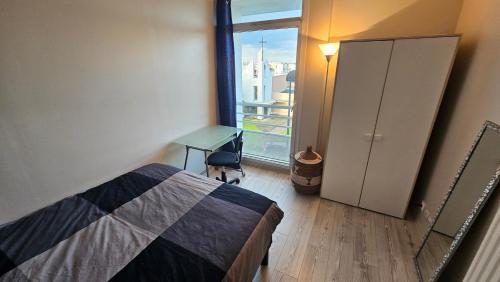 - une chambre avec un lit, une fenêtre et un bureau dans l'établissement Appartement en duplex agréable à Élancourt, à Élancourt