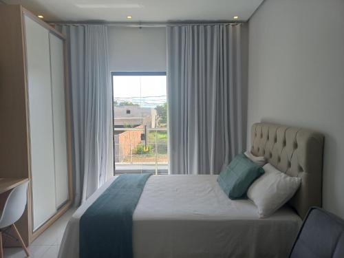 ein Schlafzimmer mit einem Bett mit einem großen Fenster in der Unterkunft apto. moderno, perto faculdades ulbra e católica. in Palmas