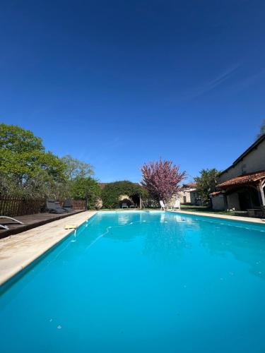 une grande piscine bleue dans une cour dans l'établissement 3-4 Cottages Entire Site Private Pool for Relaxing Holidays & Special Occasions near Aubeterre, à Saint-Romain