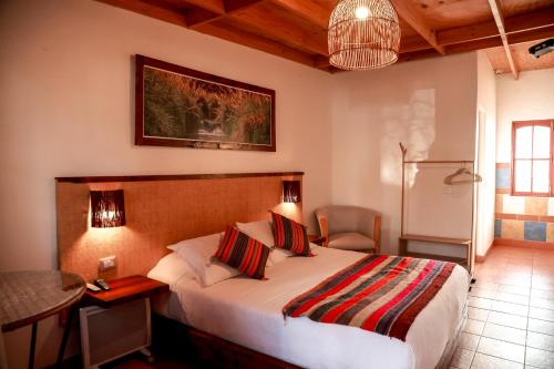 Schlafzimmer mit einem Bett, einem Schreibtisch und einem Tisch in der Unterkunft Tambo Atacama Lodge in San Pedro de Atacama
