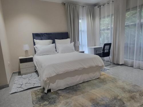 a bedroom with a large bed and a window at Sable Suites B1, 1 Bed Apartments in Kabulonga in Lusaka