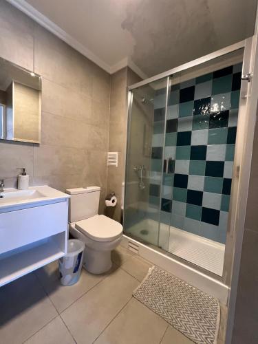 a bathroom with a toilet and a shower and a sink at Departamento 2D 2B in Los Ángeles
