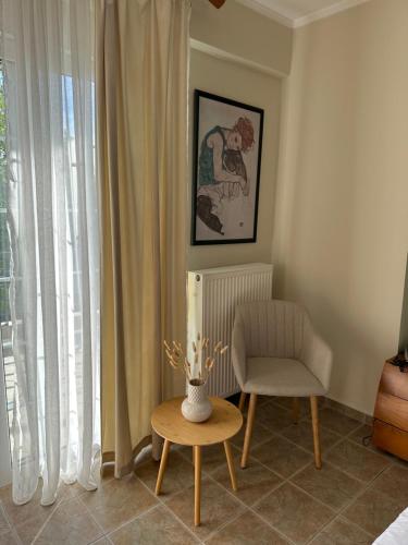 a room with a chair and a table and a vase at Villa Ariadni in Patra