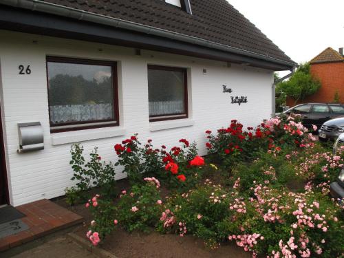 ein Haus mit einem Blumenstrauß davor in der Unterkunft Haus Halligblick, Ferienwohnungen am Wattenmeer, WhgHooge in Dagebüll