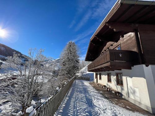 a snow covered path in front of a building at Chalet Apartments Ferius inklusive Jokercard im Sommer in Saalbach Hinterglemm