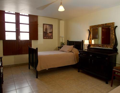 1 dormitorio con cama, espejo y tocador en Posada Galeria Alberto Sedas, en Huatusco de Chicuellar