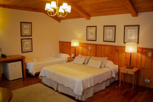um quarto com 2 camas num quarto com paredes de madeira em Hotel Solar d'Izabel em Campos de Jordão
