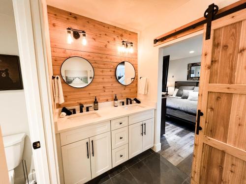 a bathroom with a sink and two mirrors at Red Poppy at the Quarry in Whitefish