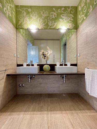 uma casa de banho com 2 lavatórios e um espelho grande em Villa Mary, relax nel cuore del Chianti em Poggibonsi