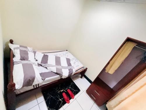 1 dormitorio con 1 cama con zapatos rojos en el suelo en Muhazi View Resort, en Muhazi