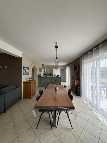 un salon avec une table en bois et un canapé dans l'établissement Au bon repos, à Maisons