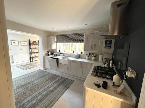a kitchen with white cabinets and a stove top oven at Tarporley No 7 in Tarporley