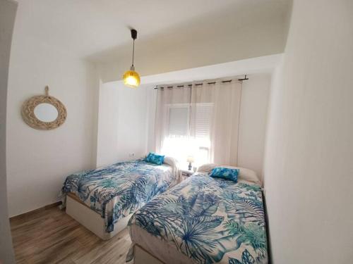 a bedroom with two beds and a window at Piso Cibeles in Cullera