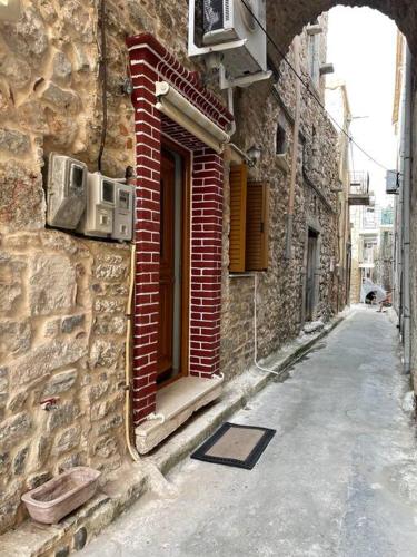 an alley with an entrance to a brick building at Traditional stone house in Pyrgi in Chios