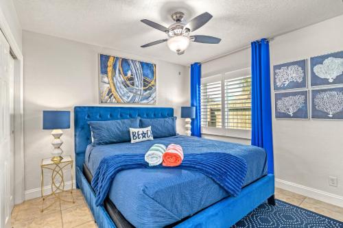 a blue bed in a bedroom with a ceiling fan at Luxury Suite| Beach| Fishing| Dock in St Pete Beach