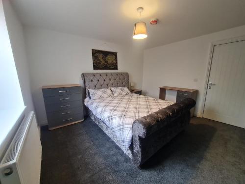 a bedroom with a bed with a couch and a dresser at Cozy 6 Bedroom HMO in Eston