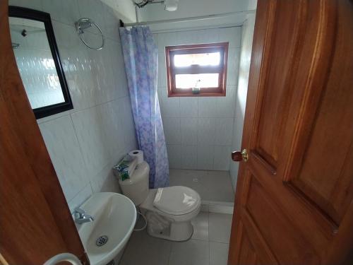 La salle de bains est pourvue de toilettes, d'un lavabo et d'une fenêtre. dans l'établissement Villa Bugambilia, à Villa de Leyva