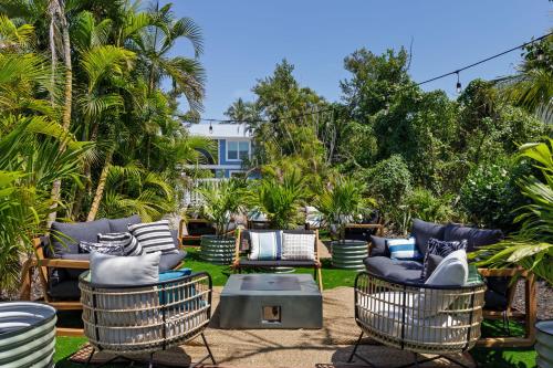 a patio with chairs and a table and trees at Palm Retreat - 3BR Cottage at the Palmview Inn of Sanibel Island with Bikes in Sanibel