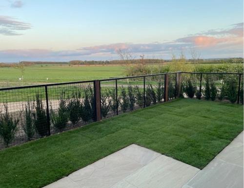 a balcony with green grass and a fence at The Linhay in Peterborough