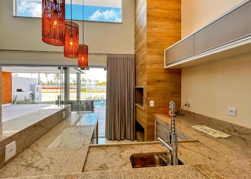 uma cozinha com um lavatório e uma grande janela em Casa com lazer proxima da Praia do Mosqueiro SE em Aracaju