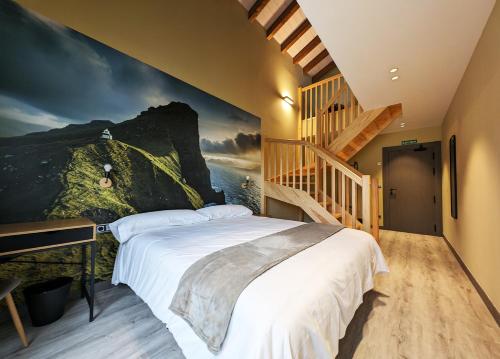 ein Schlafzimmer mit einem großen Bett und einer Treppe in der Unterkunft Hotel Rural Milaleku 