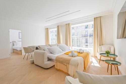 - un salon blanc avec un lit et une table dans l'établissement Luxurious & Famous Parisian Flat, à Paris
