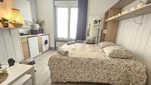a small bedroom with a bed and a kitchen at Le Girod #Proche Centre#Confort in Clermont-Ferrand