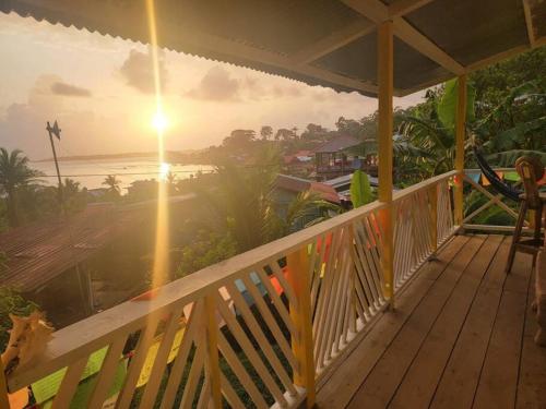eine Veranda mit Blick auf das Meer und den Sonnenuntergang in der Unterkunft Vacaciones en mar y naturaleza in Bastimentos