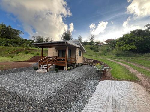 a small cabin with a roof on a gravel road at Tuna House in Maroe