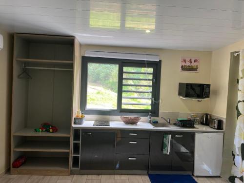 een keuken met een wastafel en een raam bij Tuna House in Maroe