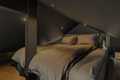 un letto in una stanza con una parete nera di Moderne hytte med fjordutsikt og spabad 25.min. fra Bergen sentrum a Bergen