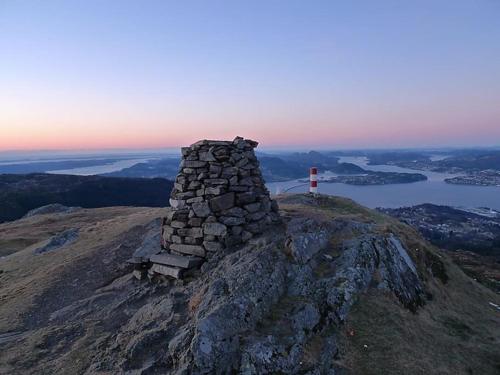 a stone tower on the top of a mountain at Moderne hytte med fjordutsikt og spabad 25.min. fra Bergen sentrum in Bergen