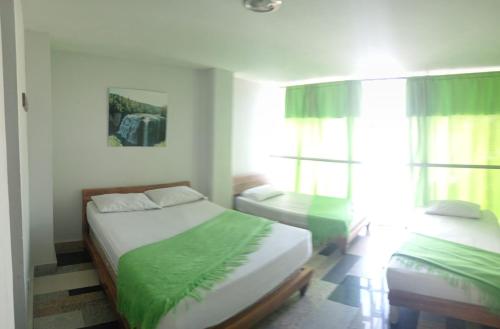 a bedroom with two beds and a window at HOTEL UNICO MEDELLIN S.A.S in Medellín