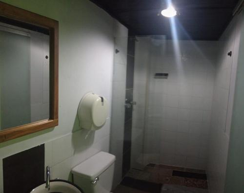 a bathroom with a toilet and a shower with a light at HOTEL UNICO MEDELLIN S.A.S in Medellín