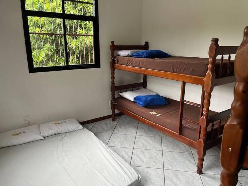 Cette chambre comprend 2 lits superposés et une fenêtre. dans l'établissement Recanto do Amiguinho, à Vila Velha