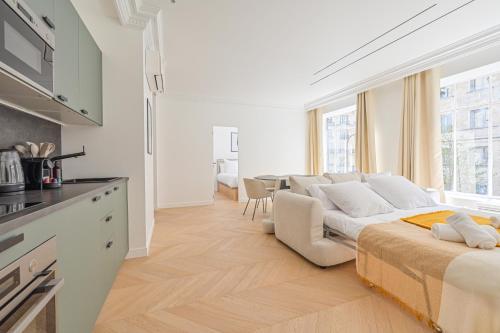 un salon blanc avec un canapé et une table dans l'établissement Luxurious & Famous Parisian Flat, à Paris