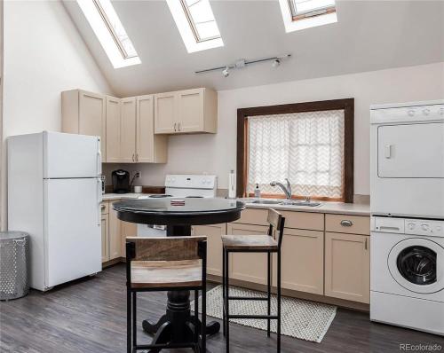 eine Küche mit weißen Geräten sowie einem Tisch und Stühlen in der Unterkunft City Park Casita Walk To Eats Brews Park More in Denver