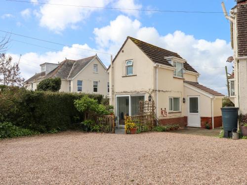 a house with a gravel driveway in front of it at Wisteria Cottage in Exmouth