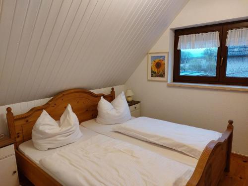 1 dormitorio con 1 cama con sábanas blancas y ventana en Holiday house to the stork's nest, Storkow, en Storkow