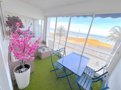 a living room with a table and chairs and a view of the ocean at La perle du Grau : T1 avec exceptionnelle vue mer in Le Grau-du-Roi