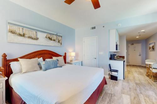 a bedroom with a large bed and a kitchen at Splash Resort 1901W Suite A Studio in Panama City Beach