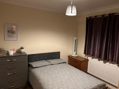 1 dormitorio con 1 cama, vestidor y ventana en Sw17 7ls en Londres