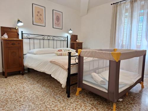 ein Schlafzimmer mit einem Bett und einem Kinderbett in der Unterkunft Casa Vacanze La Barca in Fiattone
