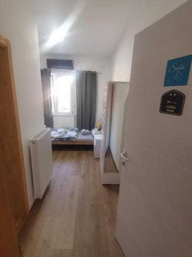 a hallway with a room with a bed and a window at V&U Sobe in Brzi Brod