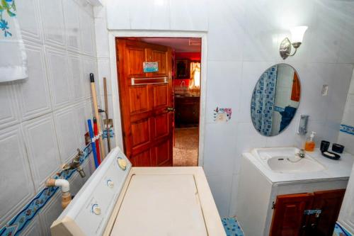 uma pequena casa de banho com um lavatório e um espelho em Casa Rosa em Georgetown