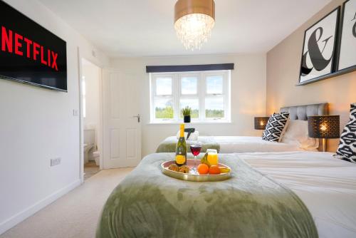 a bedroom with two beds and a table with fruit on it at Luxury Show Home in Prime Location - Sleeps up to 6 Guests - Free Parking, Fast Wifi, SmartTV with Netflix and Private Garden by Yoko Property in Milton Keynes