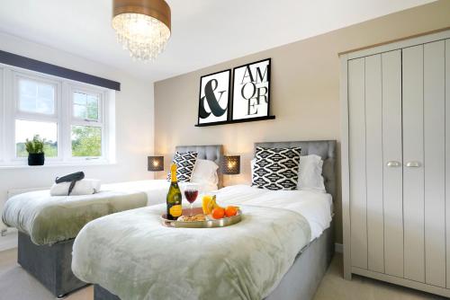 ein Schlafzimmer mit 2 Betten und einem Tablett mit Obst darauf in der Unterkunft Luxury Show Home in Prime Location - Sleeps up to 6 Guests - Free Parking, Fast Wifi, SmartTV with Netflix and Private Garden by Yoko Property in Milton Keynes