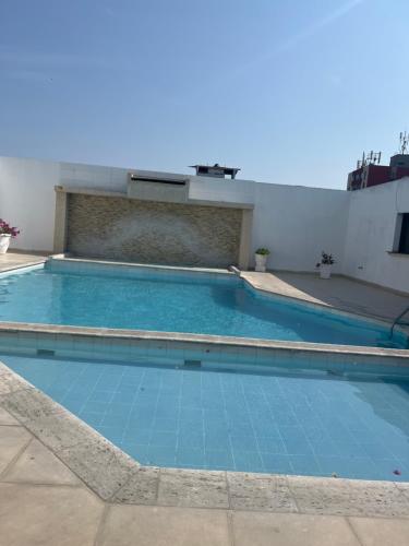 una gran piscina con azulejos azules. en Hotel Doral Barranquilla, en Barranquilla