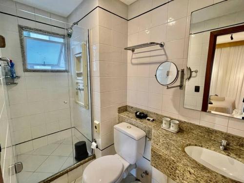 La salle de bains est pourvue de toilettes, d'un lavabo et d'une douche. dans l'établissement Flat Vista para o Mar/Piscina/Cama Queen/Ar, à Vitória