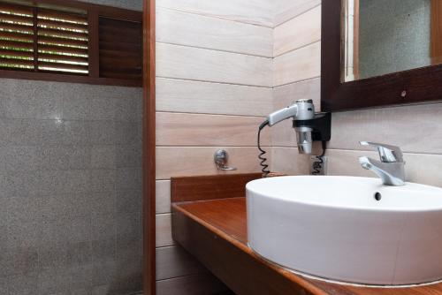La salle de bains est pourvue d'un lavabo blanc et d'un miroir. dans l'établissement Villa Terai 2BR Legends Moorea wPool, à Papetoai